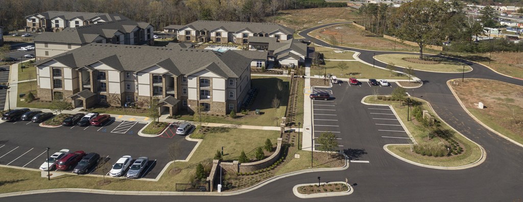 A parking lot in front of a building with a curved road.