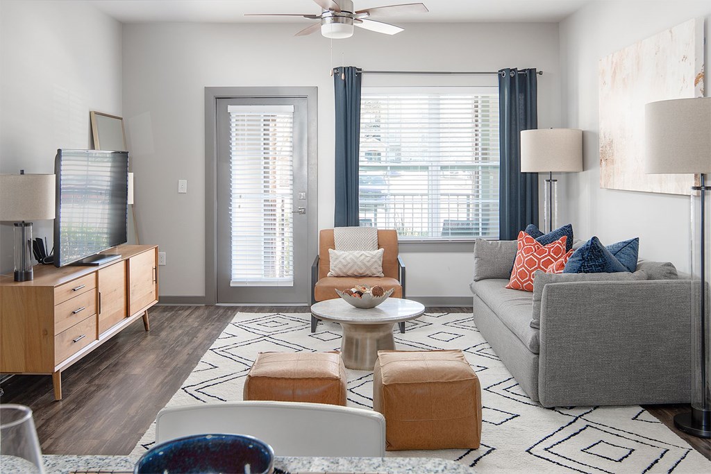 A living room with a grey couch, a coffee table, and a ceiling fan.