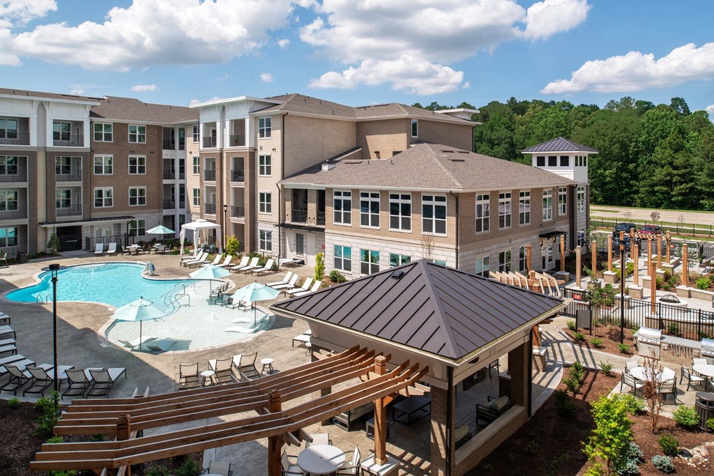 A large building with a pool in front of it.