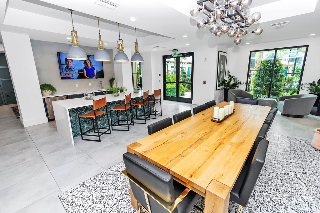 a clubhouse dining room with a long wooden table and black chairs