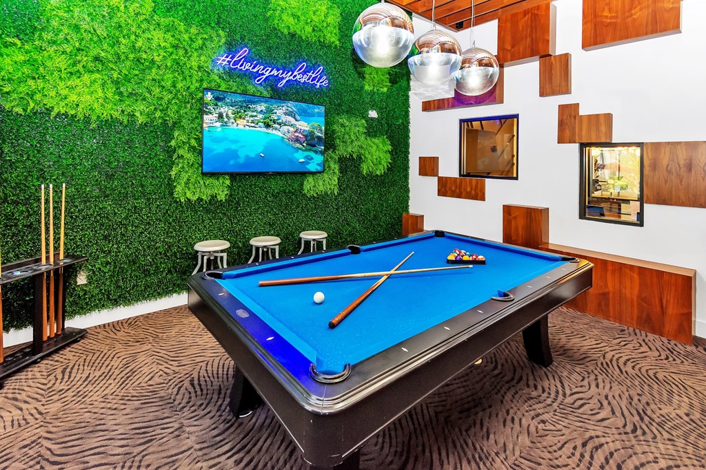 a game room with a pool table and a tv