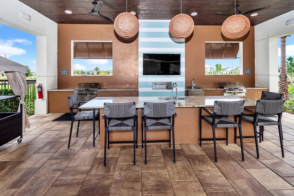 a patio with a table and chairs and a grill