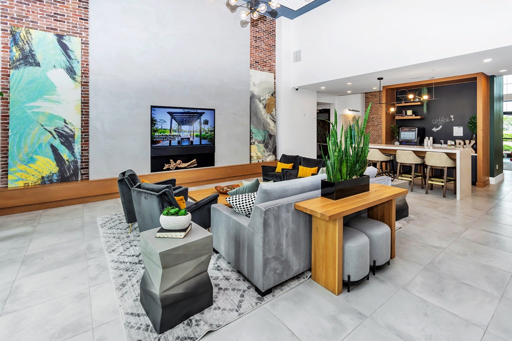 a clubhouse living room filled with furniture and a large painting on the wall