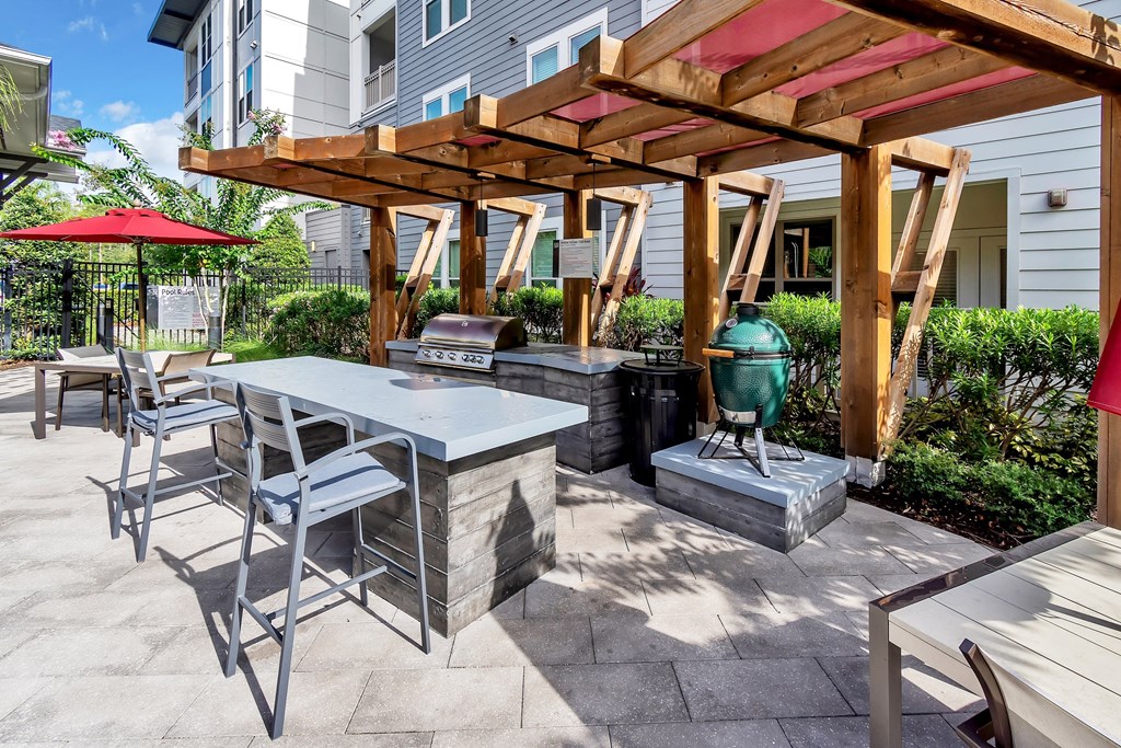 a patio with a table and chairs and a grill