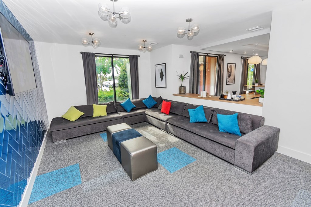 a living room with a large grey couch and blue and yellow pillows