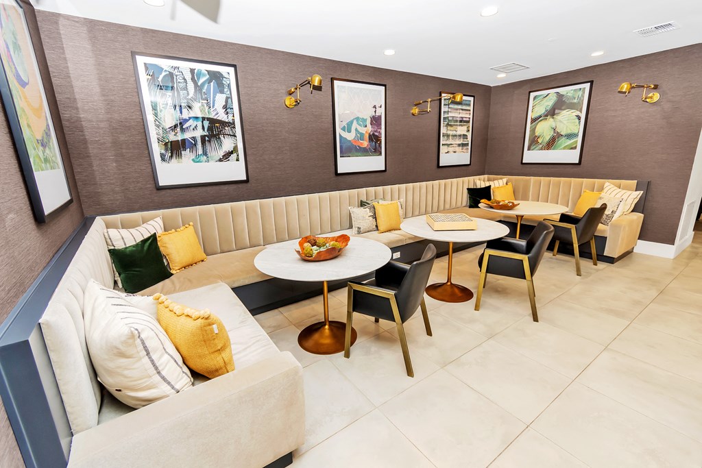 a seating area with tables and chairs in front of a couch