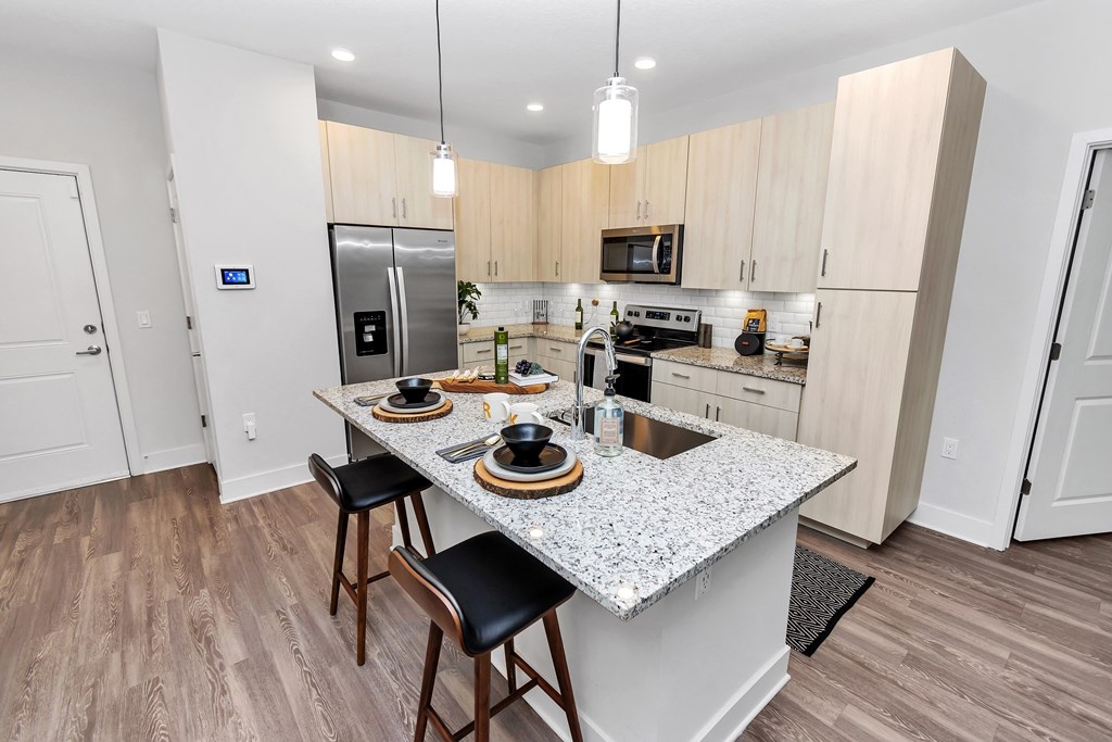 a kitchen with a large island with a granite countertop