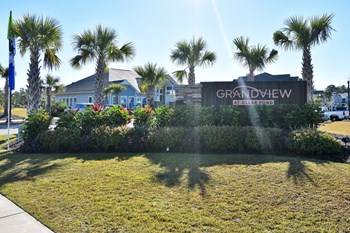 Grandview at Clear Pond street entrance sign with grass, flowers, and palm trees near parking - Photo Gallery 12