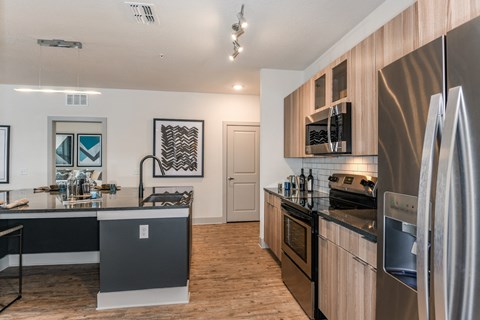 an open kitchen with stainless steel appliances and a counter top