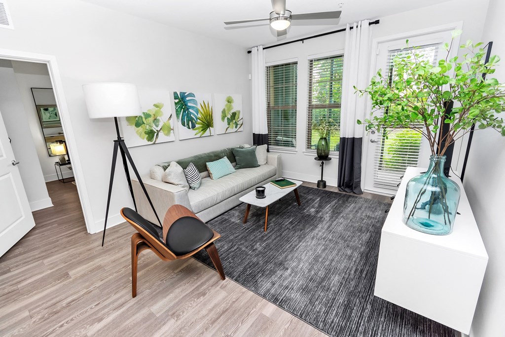 a living area with a couch coffee table and a large window