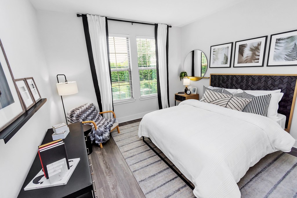 a bedroom with white bedding and black and white decor
