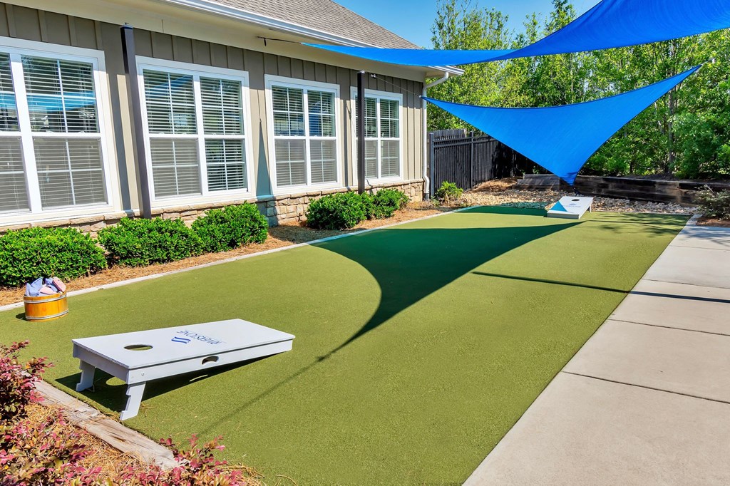 Riverstone outdoor game area with cornhole game