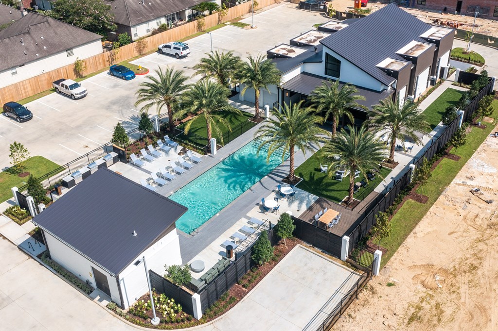An Apartment Community with a pool and palm trees.