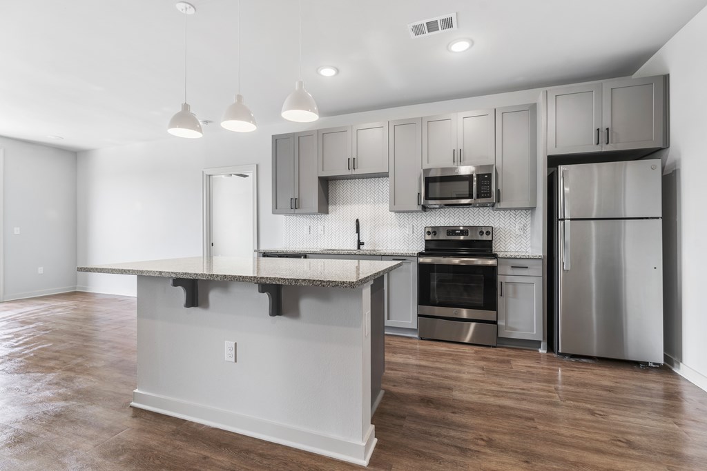 A kitchen with a large island and stainless steel appliances.