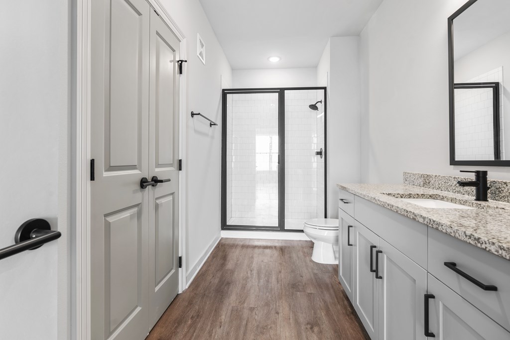 A bathroom with a toilet, sink, and mirror.