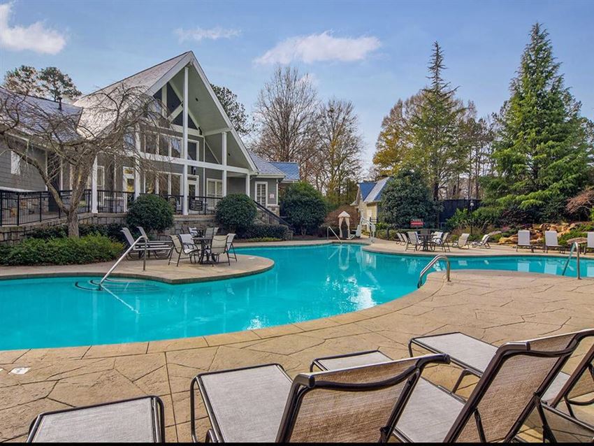 Resort-style pool with a sundeck that has lounge chairs and tables at Manchester Place Apartments in Lithia Springs, GA