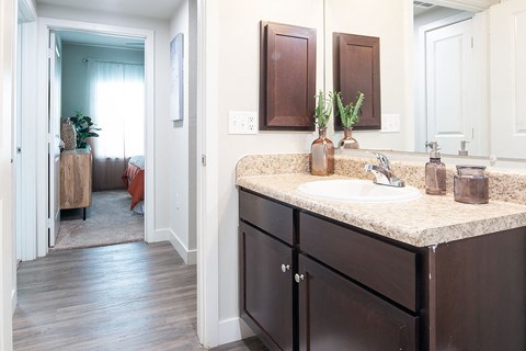 a bathroom with a sink and a door to a bedroom