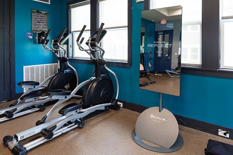a spin class room with treadmills and a mirror in a gym
