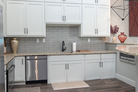 a clubhouse kitchen with white cabinets and a counter top