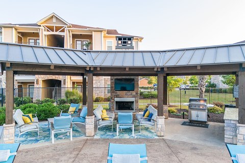 a covered patio with chairs and a fire pit