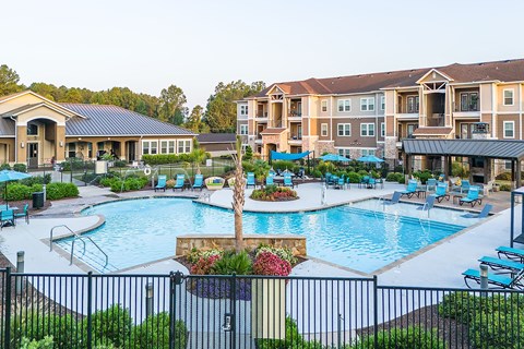 an outdoor swimming pool with an apartment building in the background