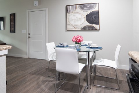 a dining room with a table and chairs and a painting on the wall