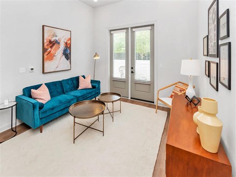 Living room with recessed lighting, wall thermostat, hard floors and double doors to a patio