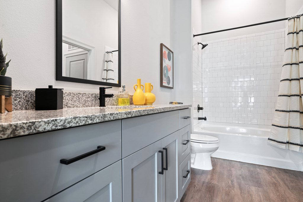 A bathroom with a white toilet and a white bathtub.