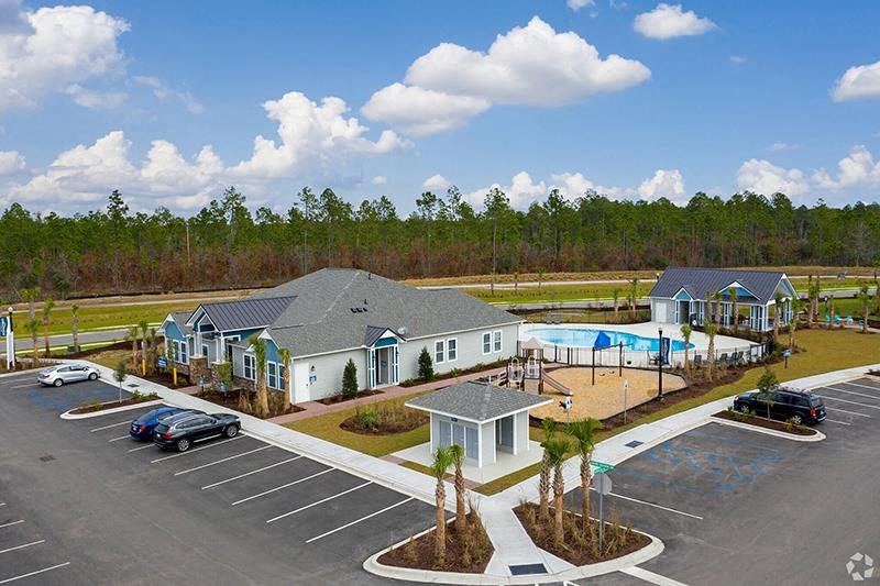 an aerial view of a house and a swimming pool in a parking lot