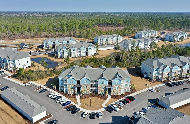 an aerial view of an apartment complex with a parking lot