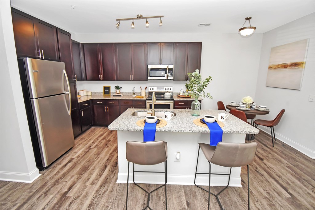 a kitchen with a large island with a breakfast bar and stainless steel appliances