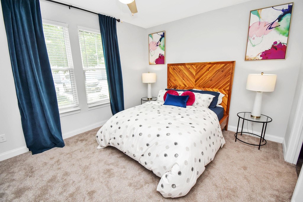 a bedroom with a bed and two windows