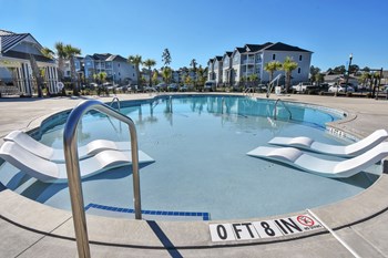 View of the Pool’s Baja shelf with water immersed lounge chairs looking towards apartments - Photo Gallery 13