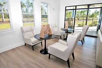 Clubhouse seating area with chairs, coffee tables, a Connect 4 game, and a Jenga game near windows - Photo Gallery 2