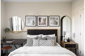 Model bedroom with work black and white decor, desk, bed, bedside table, and pictures - Photo Gallery 5
