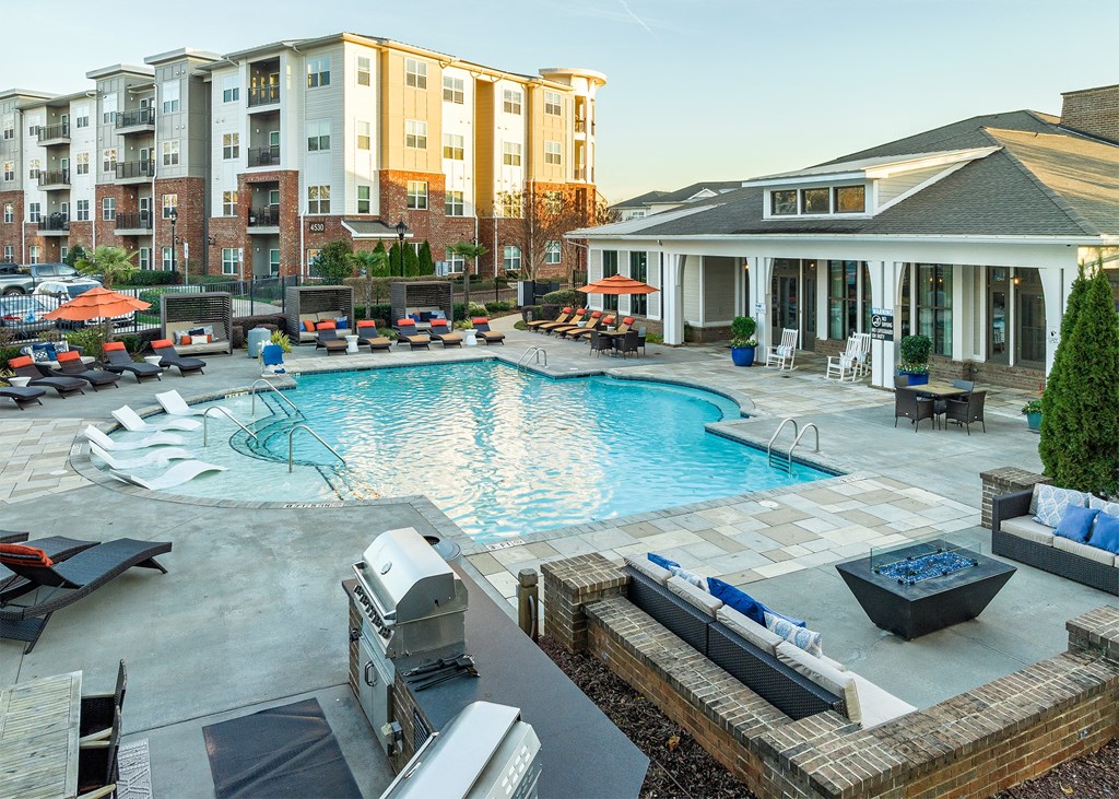 a swimming pool with lounge chairs and apartments in the background