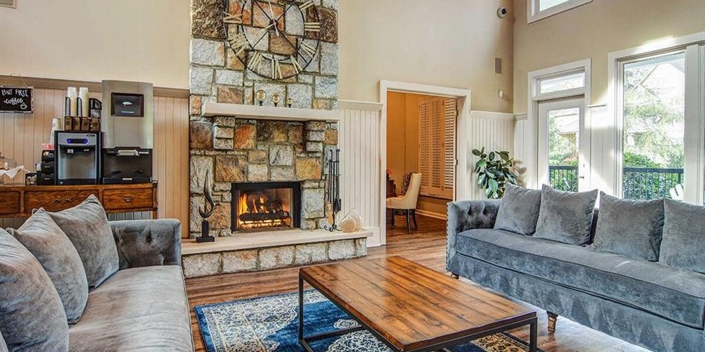 Resident lounge furnished with upholstered couches, fireplace and coffee bar at Manchester Place Apartments