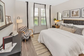 Apartment bedroom with hard floors and natural light coming from double windows on wall - Photo Gallery 4