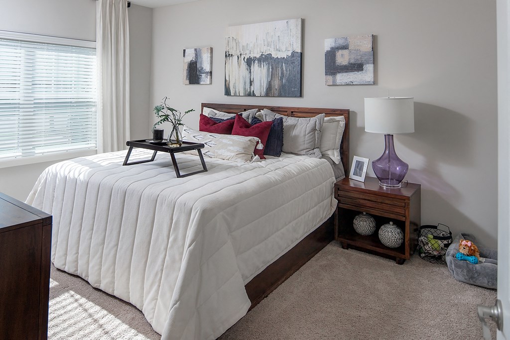 a bedroom with a bed with white sheets and pillows
