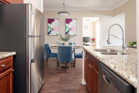 a kitchen and dining room with stainless steel appliances and granite counter tops