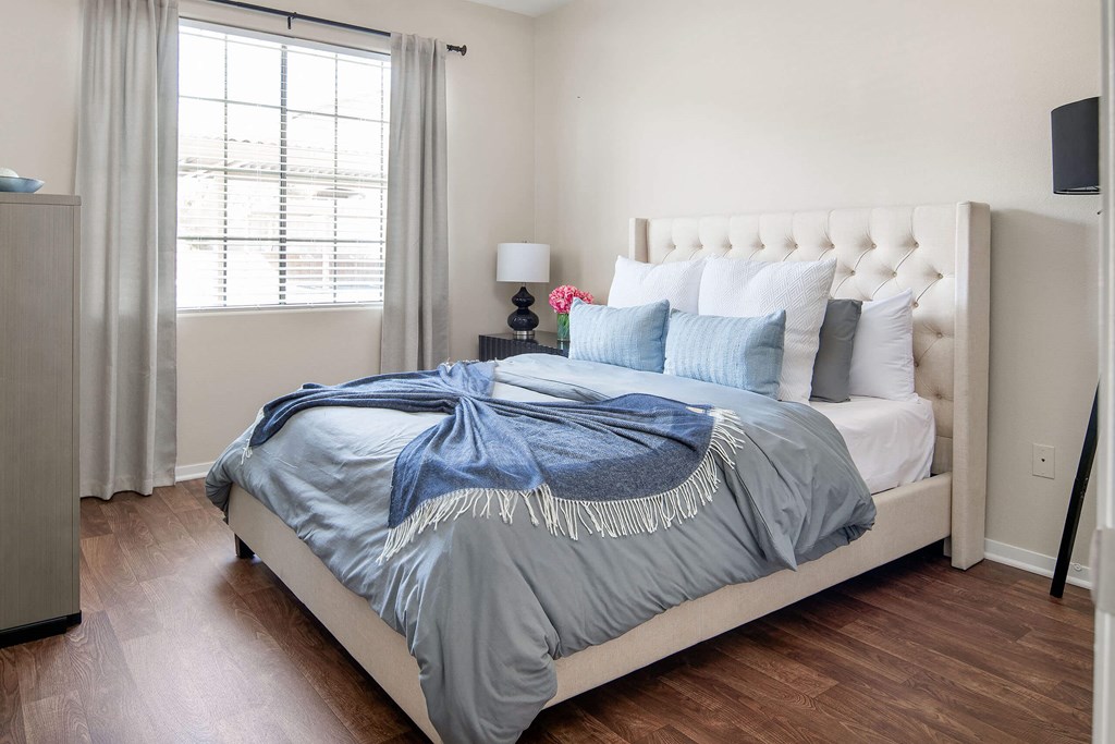 a bedroom with a bed with blue blankets and pillows