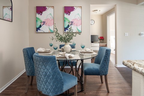 A dining room with a table set for two and two chairs.