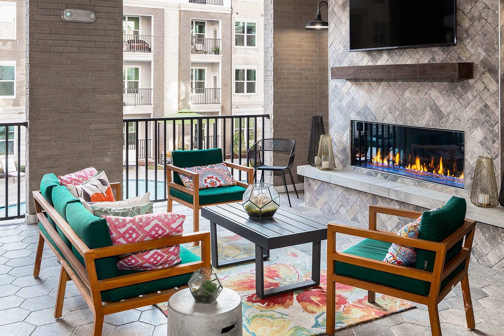 a outdoor lounge with a fireplace and a balcony