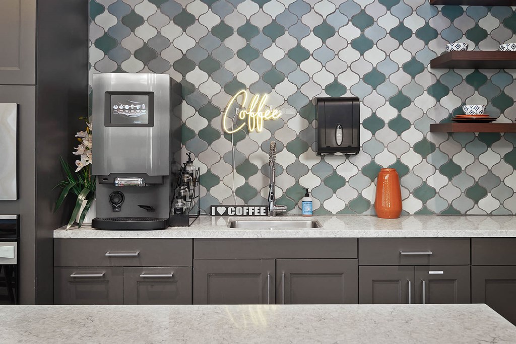 a coffee maker on a counter and a tile wall