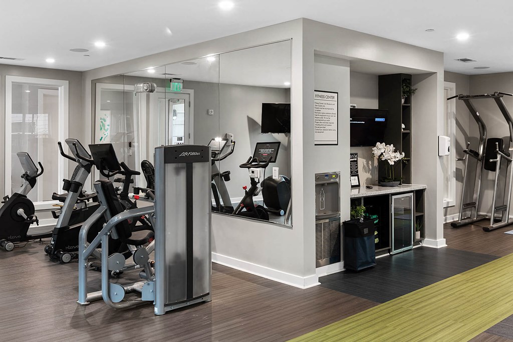 a gym with cardio equipment and weights in a building