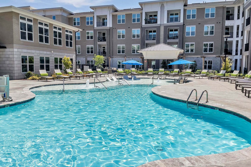 a swimming pool with an apartment building in the background