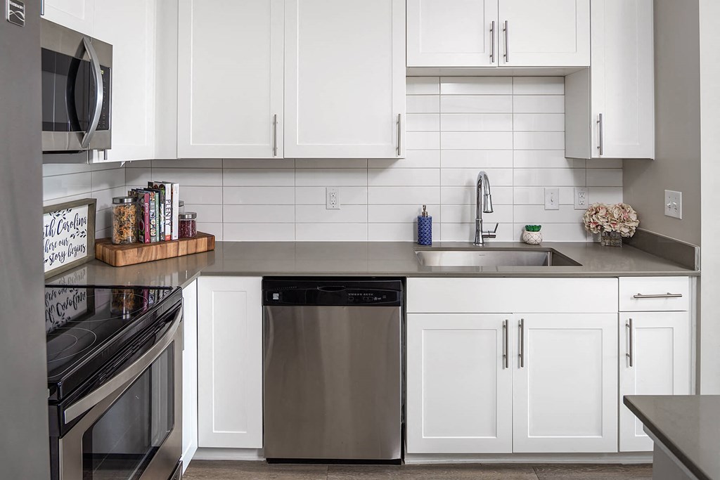 a white kitchen with stainless steel appliances and white cabinets