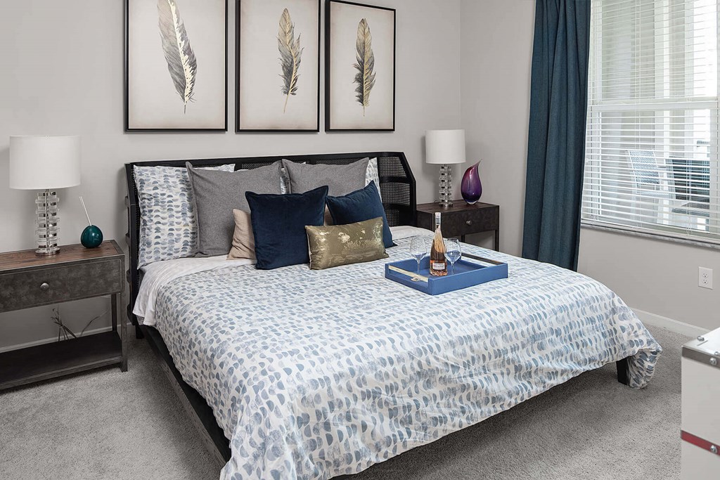 a bedroom with a bed with blue comforter and pillows