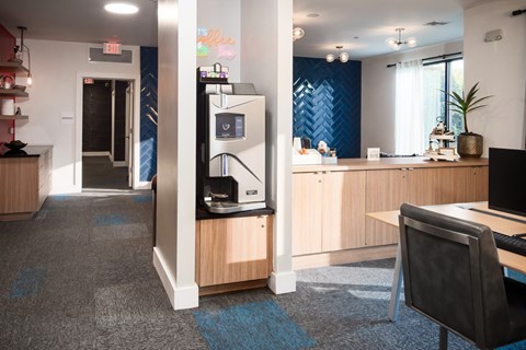 A modern office space with a desk, chair, and a coffee machine.