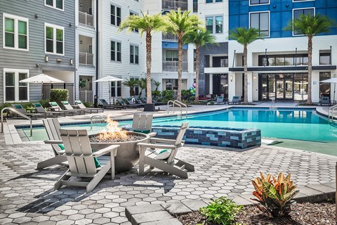 A poolside area with chairs and a fire pit.